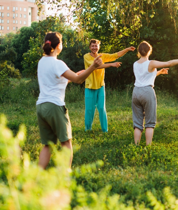 Auf dem Bild sind Teilnehmer*innen in Sportkleidung zu sehen die in einem Park am Programm von Bewegt im Park teilnehmen.