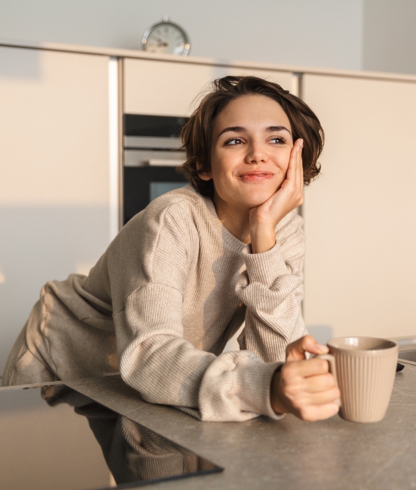 Das Bild zeigt eine Frau die eine Tasse mit einem Heißgetränk hält und offenbar entspannt wirkt. Sie schont ihre Stimme nach dem Festival.
